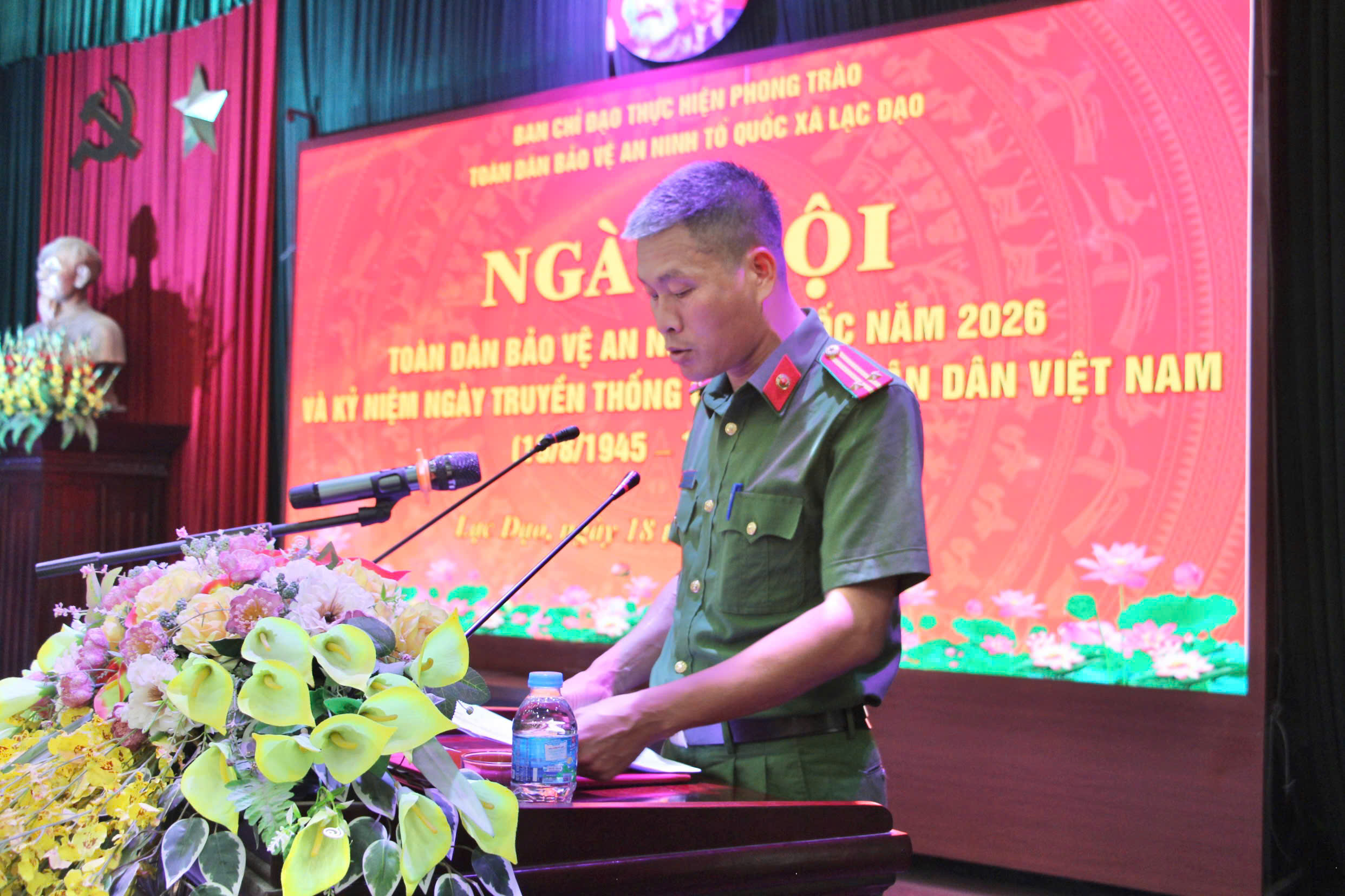 Đồng chí Trung tá Hoàng Thế Quân - Phó trưởng Công an xã báo cáo đánh giá kết quả triển khai thực hiện công tác xây dựng phong trào Toàn dân bảo vệ an ninh Tổ quốc 6 tháng đầu năm 2026